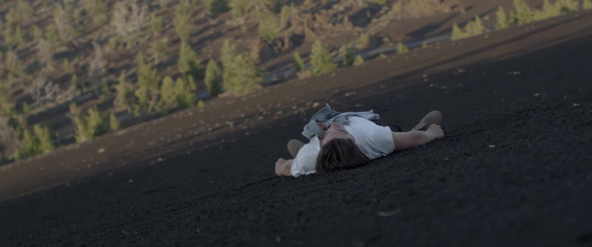 A man lying on the ground with his jacket on his chest