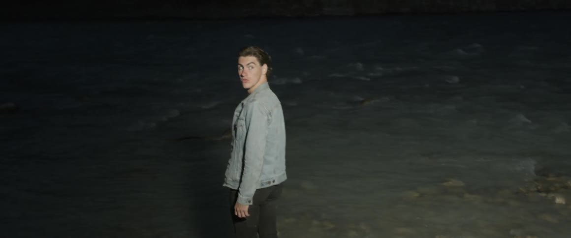 Man walks in the dark and turns around to look behind him