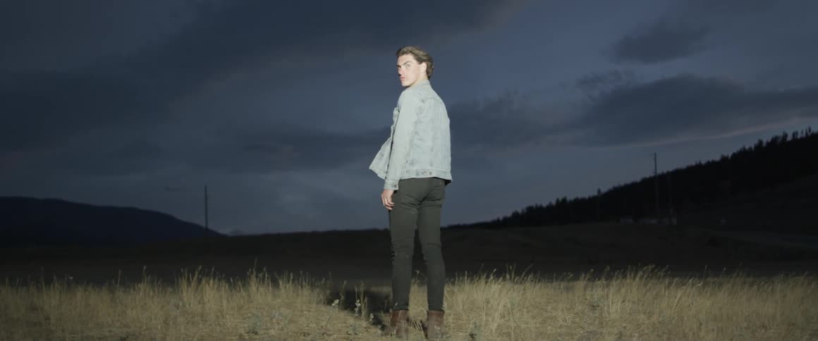 A man stands on the field with a light on him