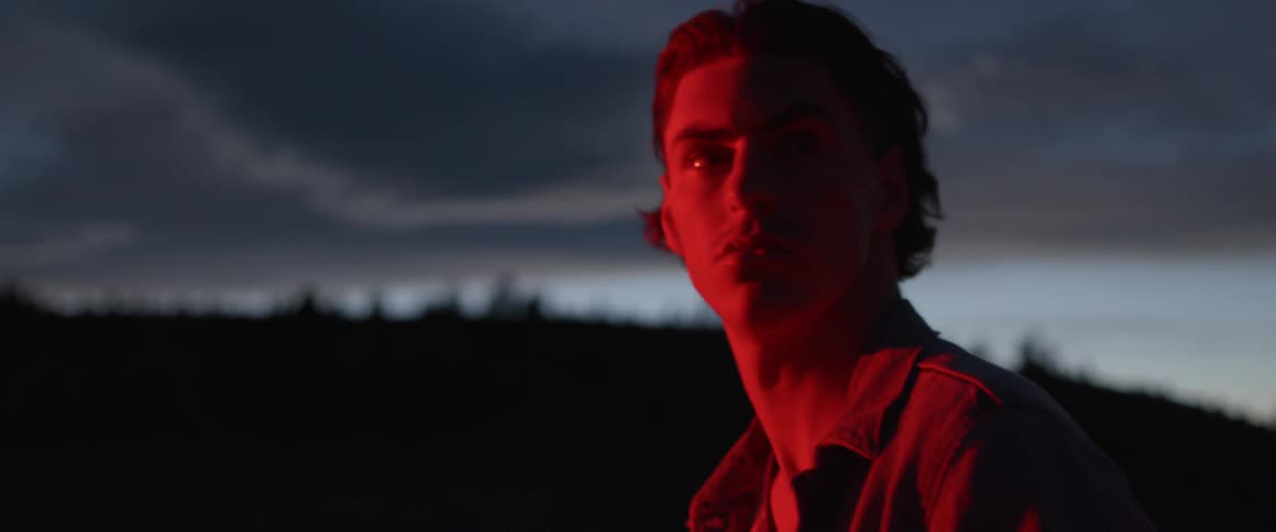 A man looks towards a red illumination