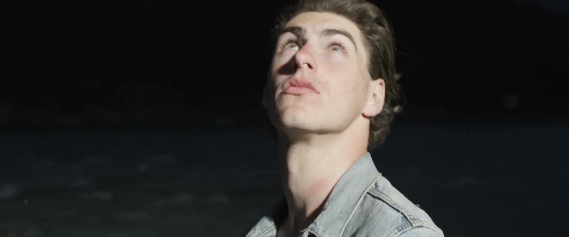 Man looks behind him then looks up towards the sky