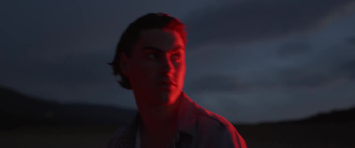 Man turns around and blinks as he stands in the dark
