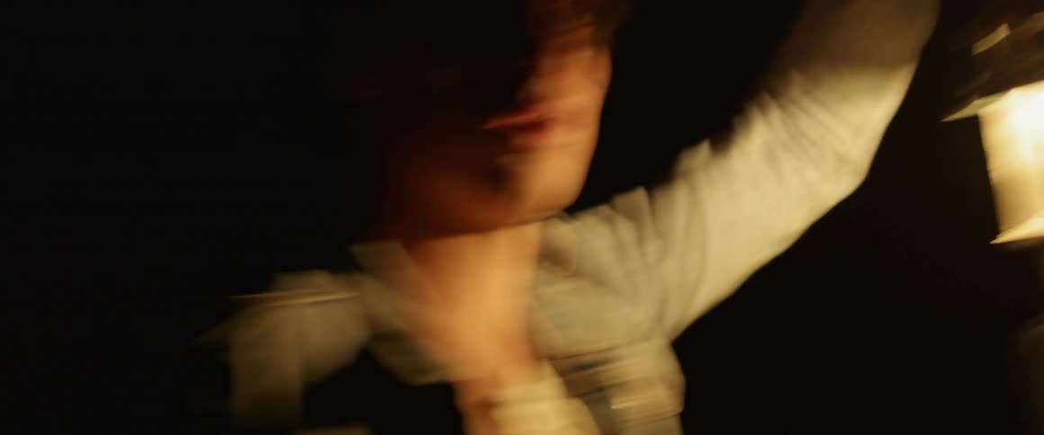 A man is searching around at night with a lantern