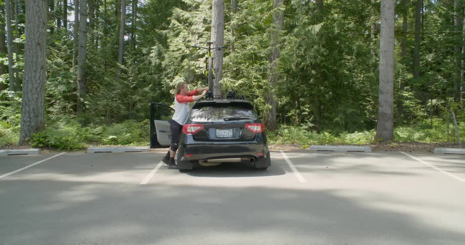A person attaches a bike on the car