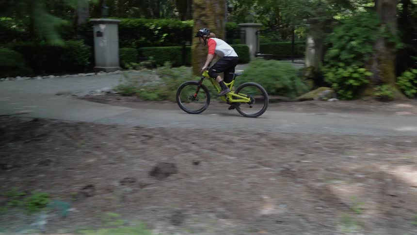 Man rides a bicycle on a path near the trees
