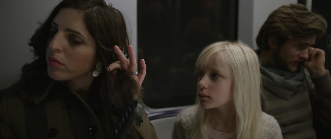 A woman brushes her hair on the subway
