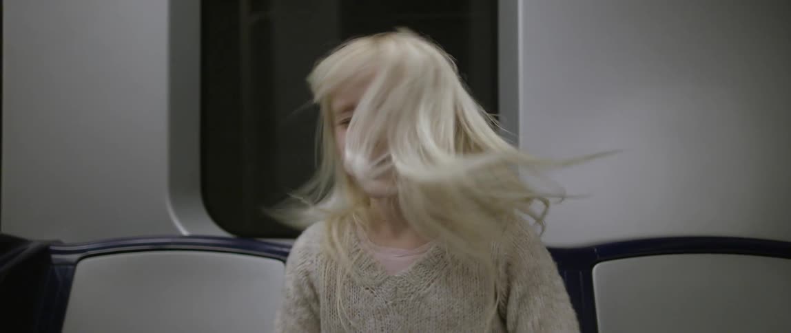 A girl shakes her hair around on the subway