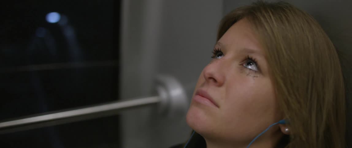 Woman looking at ceiling while riding public transportation