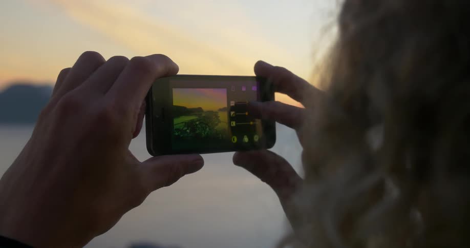 A woman takes a photograph with her smartphone