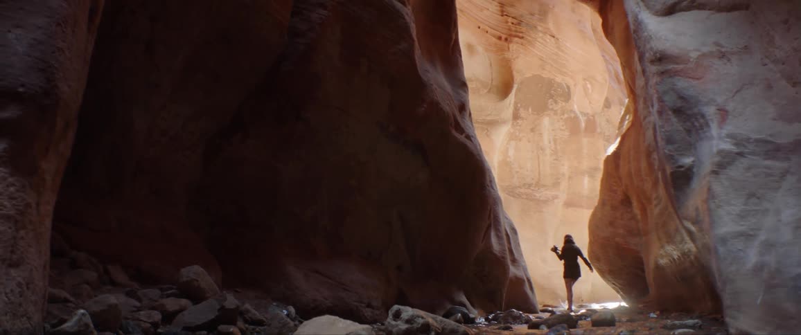 A woman is walking in the water in the cavern