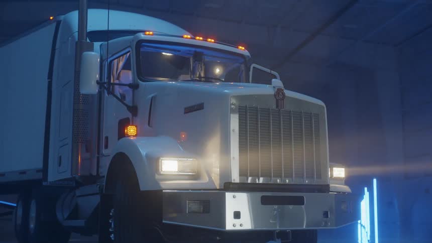 Man is getting into white semi truck parked in warehouse