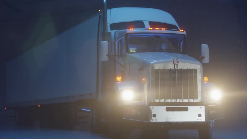 Headlights shine on a semi-truck