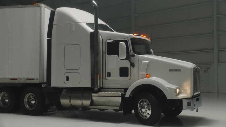 A semi-truck is parked in a warehouse
