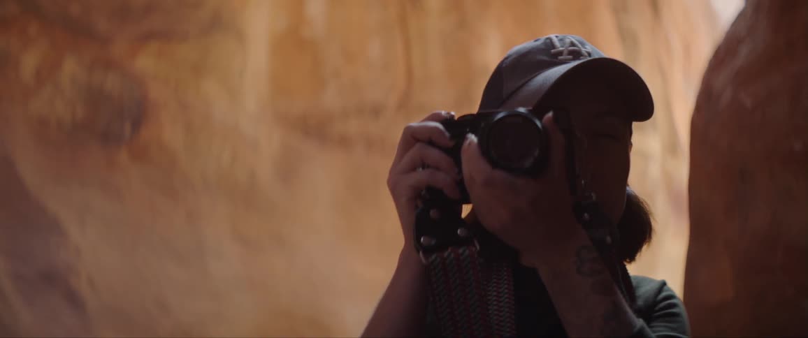 A woman raises a camera and takes a photograph