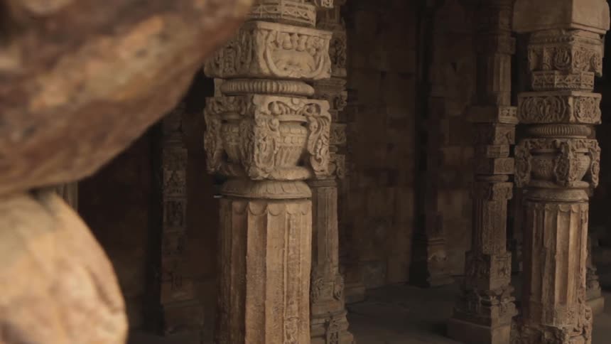 Carved stone pillars stand near a building