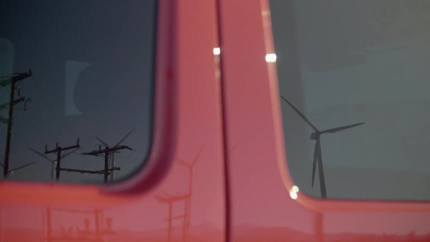 Windmills spinning are reflected on a trucks window
