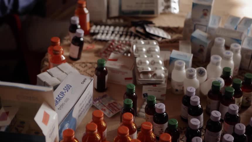 Person opens many boxes of bottles of pills