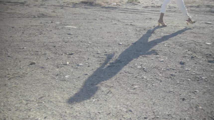 A woman walks outside in heels