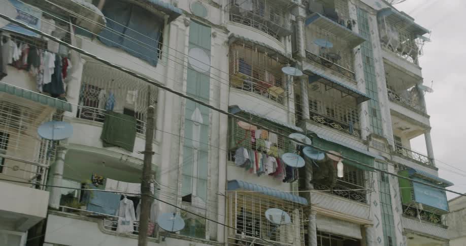 Clothes hang on apartment balconies in a city