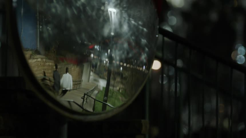 Mirror reflects two people walking down a staircase at night