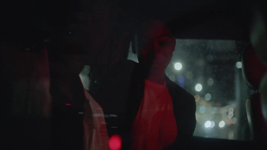 People talk in the back of a vehicle at night