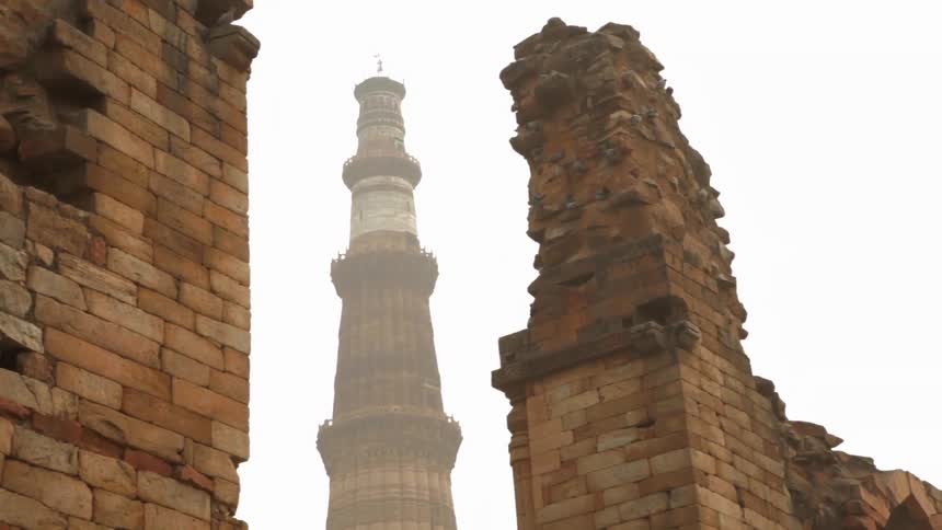 A tower stands tall into the hazy sky