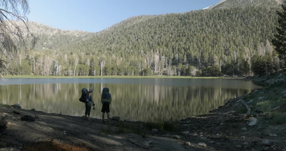Two hikers look out towards the lake