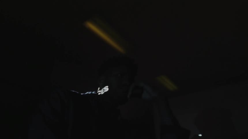 Words are displaying on a man sitting in a room with flashing lights