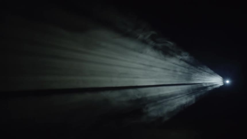 A projector lamp is illuminating smoke and dust in a dark setting