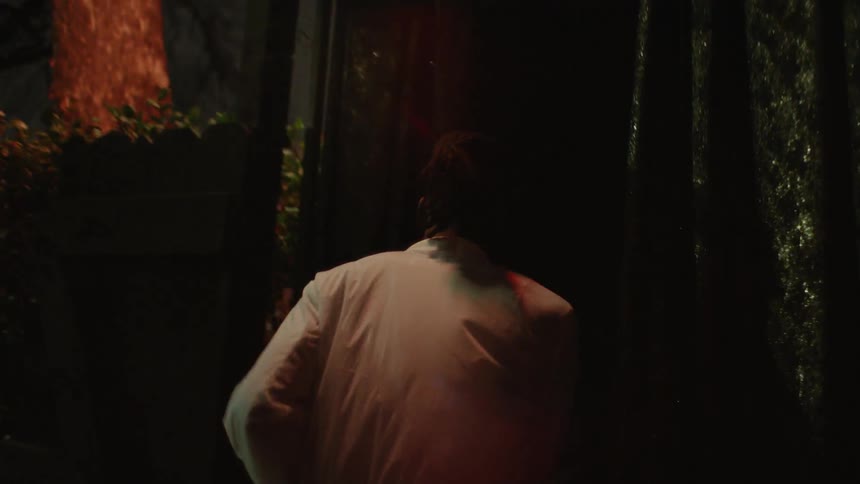 Man walks in the dark and enters a doorway