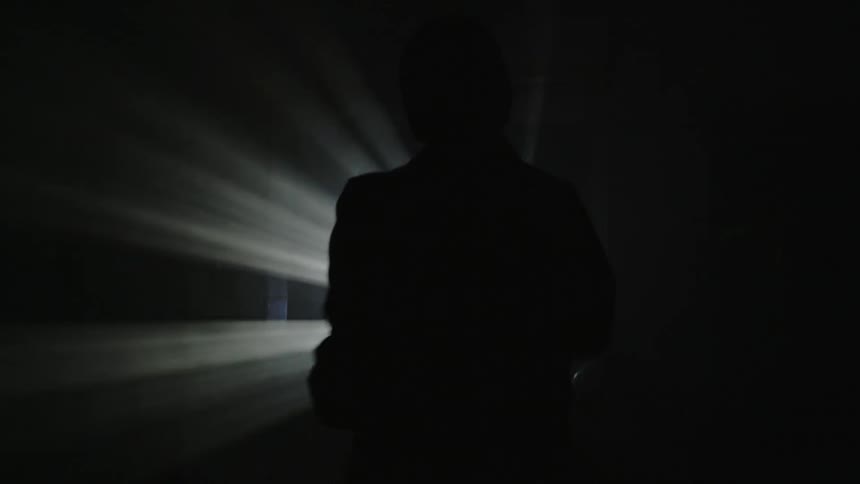 A person reaches into a projection light