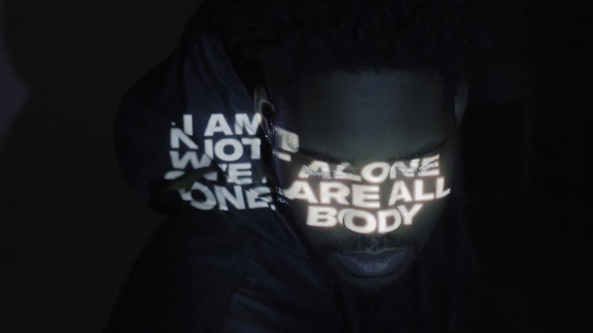A man stands in front of projected words