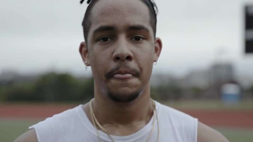 A man catches his breath on a running track