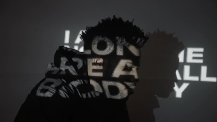 A man stands in front of projected words