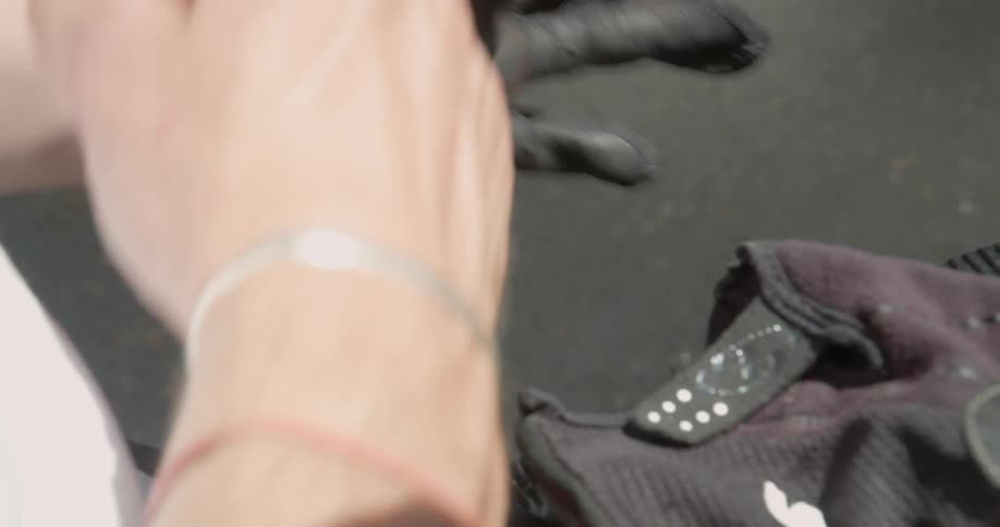 A man puts on motorcycling gloves