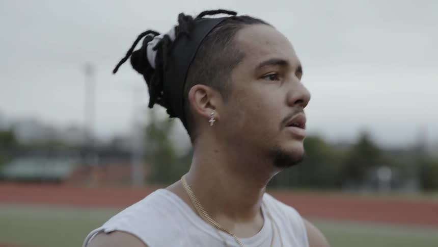 A man stops to catch his breath on an athletic field
