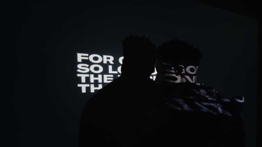 A bible verse is projected in the dark