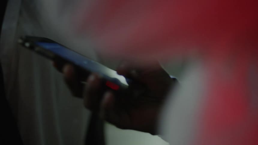 A man uses a smartphone at night