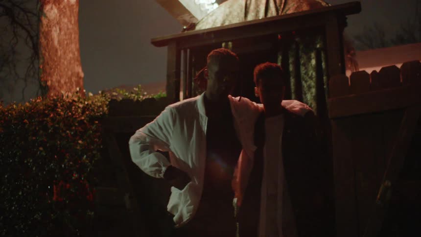 A couple exits a building through a curtain and walk away