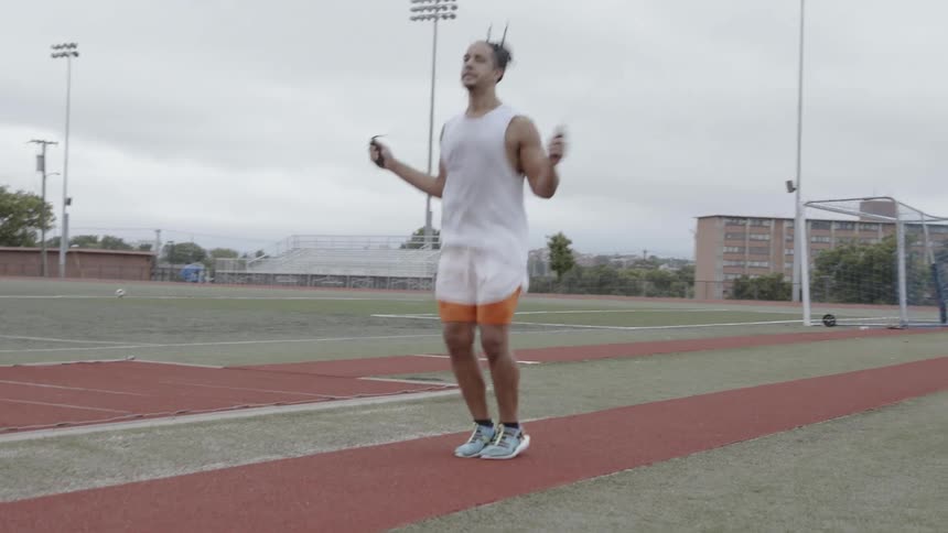 Man jumping rope at a track in the afternoon