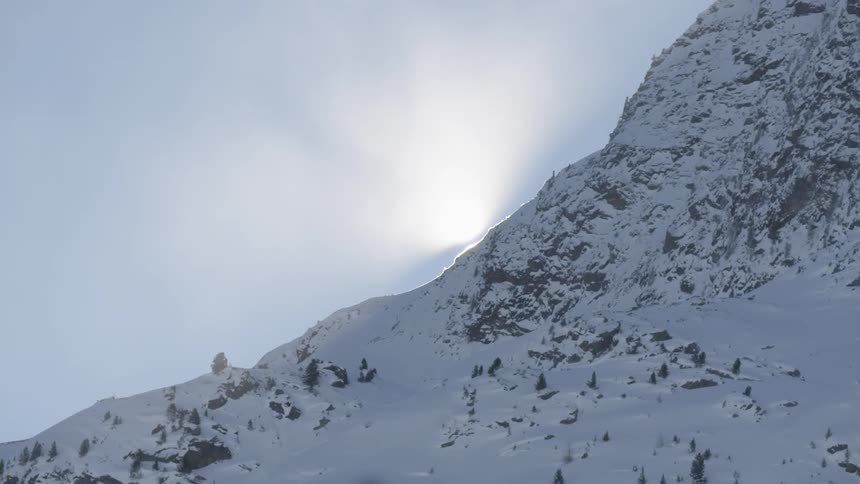 The sun shines on the snowy mountain