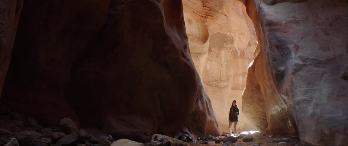 A woman looks around inside a cavern