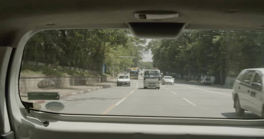 Traffic in lanes visible through a car's rear window