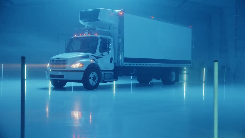 A truck parked at night with lights flashing around it