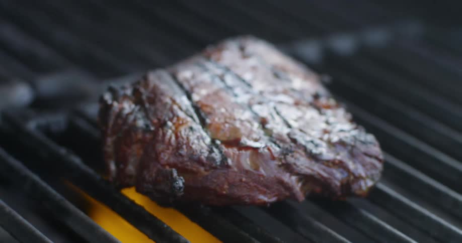 A steak is cooked on the grill