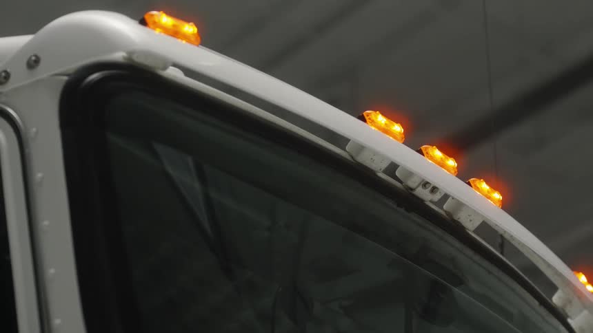 Orange marker lights in white semi truck parked in warehouse