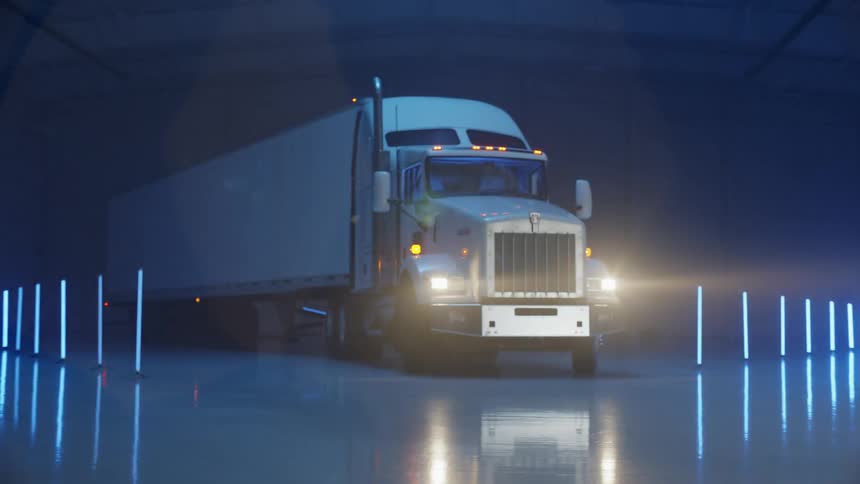 A tractor trailer is parked between the lights