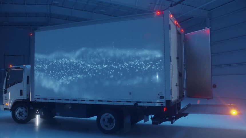 Lights are projected on the side of a large truck in a warehouse