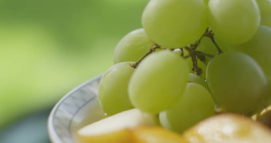 Fruit is sitting on a plate outside in daylight