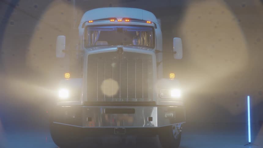 White semi truck is parked in dark warehouse